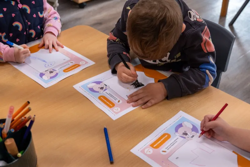 Children colouring in their workbooks