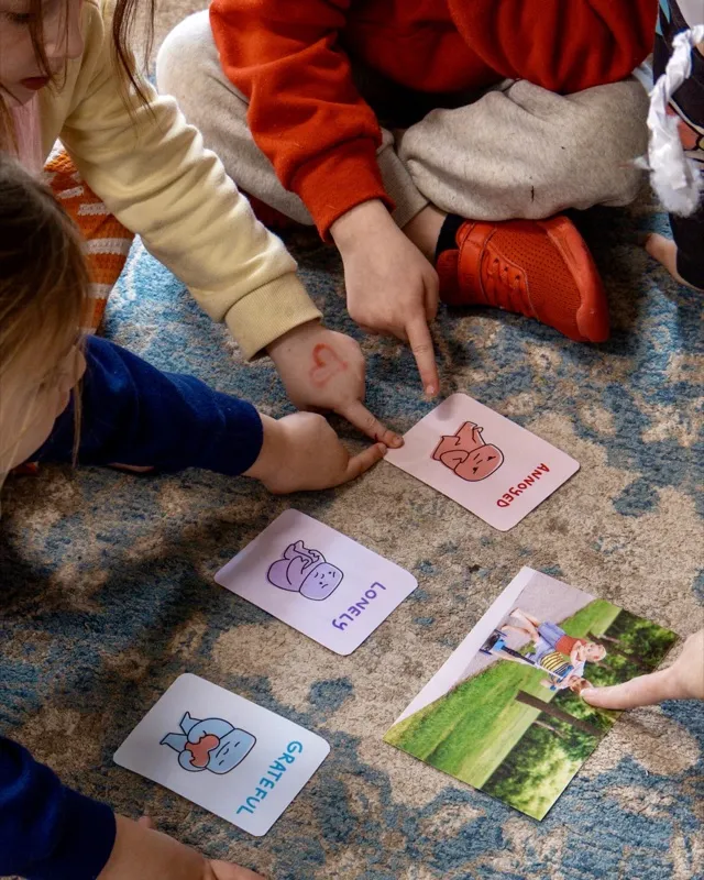 Children sorting emotion cards on the floor