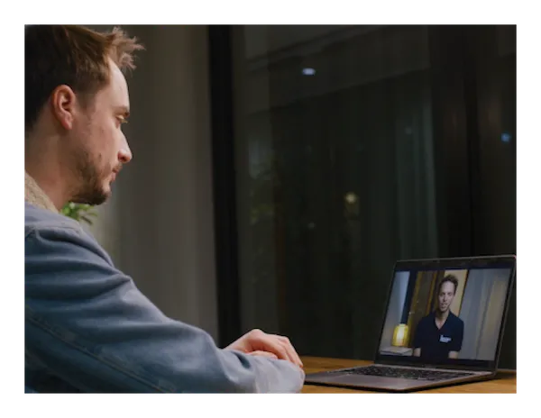 A staff member watching an online learning series module on a laptop